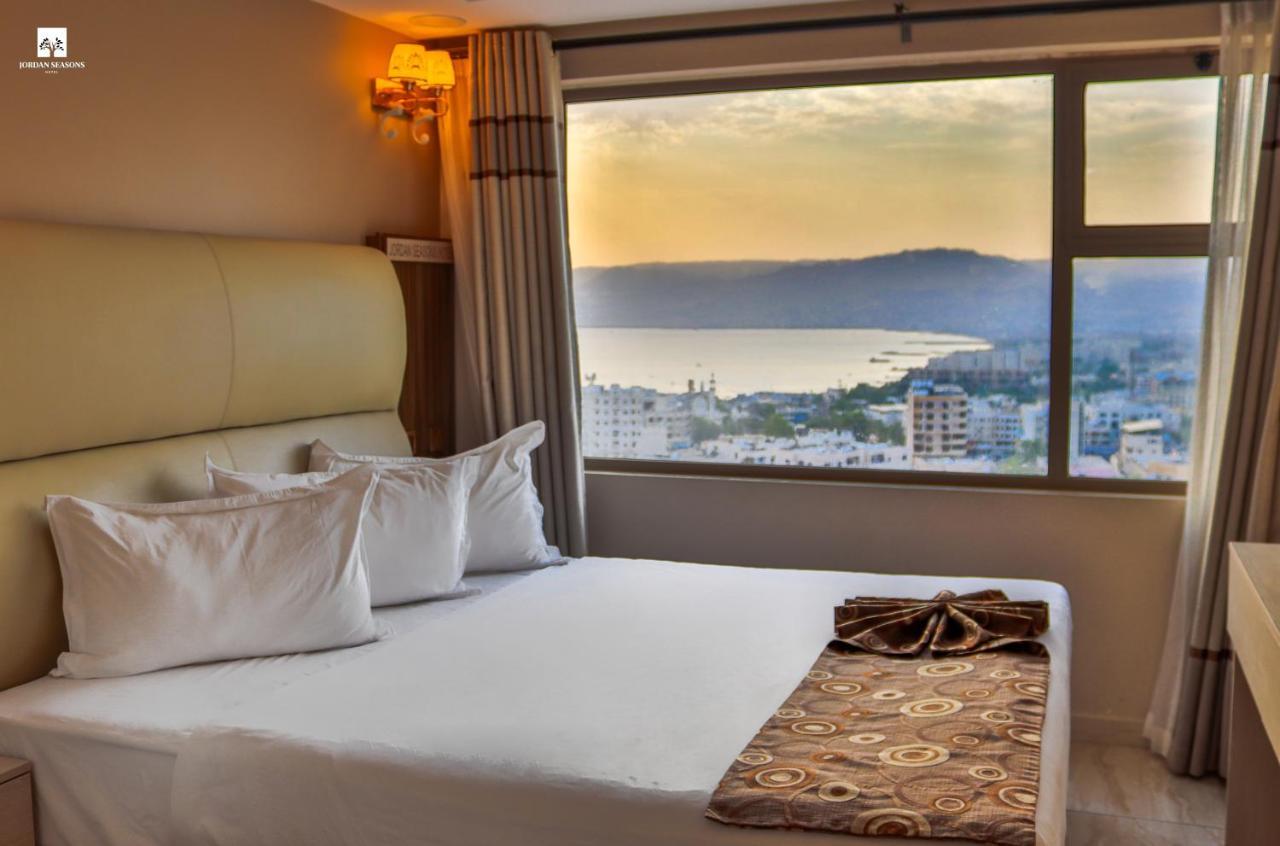 Deluxe Double Room with a wide window over the Gulf of Aqaba at sunset